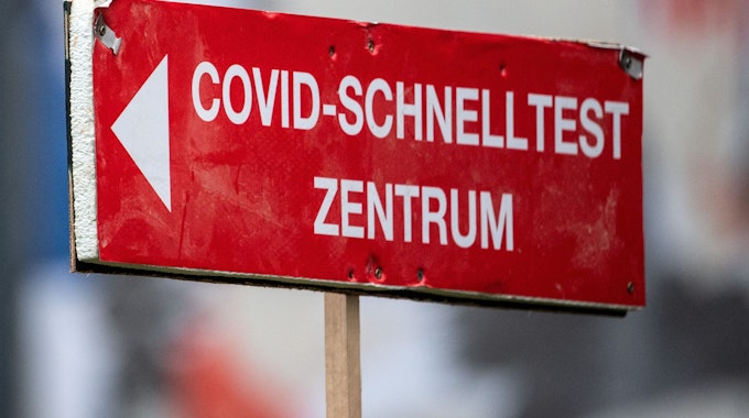 Ein Schild weist den Weg zu einem Corona-Schnelltestzentrum in Köln. Foto vom 27. Januar 2022.