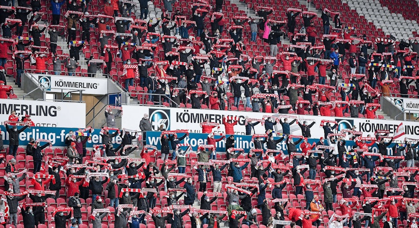 Fans des FSV Mainz 05 halten ihre Schals hoch.