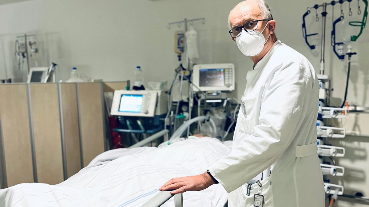 Dr. Gunther Quinkler steht am Krankenbett eines Patienten.