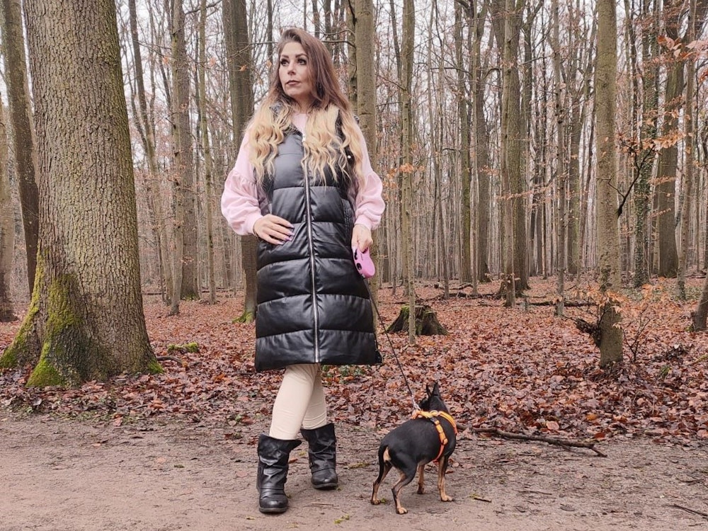 Joana N. aus Leverkusen geht im Wald mit ihrem Hund spazieren.