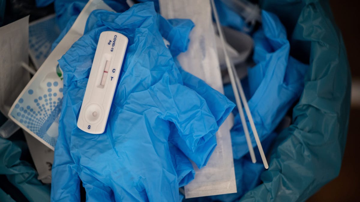 Ein negativer Covid-Schnelltest liegt auf diesem Symbolbild vom 27. Januar 2022 auf einem medizinischen Handschuh in einer Teststelle im Mülleimer. Nach falsch-positiven Ergebnissen hat die Firma Genrui Chargen ihrer Schnelltest zurückgerufen.