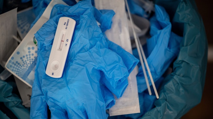 Ein negativer Covid-Schnelltest liegt auf einem medizinischen Handschuh in einer Teststelle.
