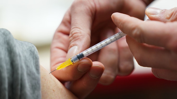 Ein Impfarzt des Mobilen Impfteams der Sozialbehörde impft im Blinden- und Sehbehindertenverein Hamburg e.V. während einer Impfaktion einen Mann. Das Bild wurde am 24. Januar 2022 aufgenommen.
