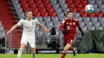 Matthias Ginter, Innenverteidiger von Borussia Mönchengladbach, im Zweikampf mit Bayern-München-Stürmer Robert Lewandowski am 7. Januar 2022 in der Allianz-Arena. Beide Spieler haben den Ball in dieser Szene im Blick.