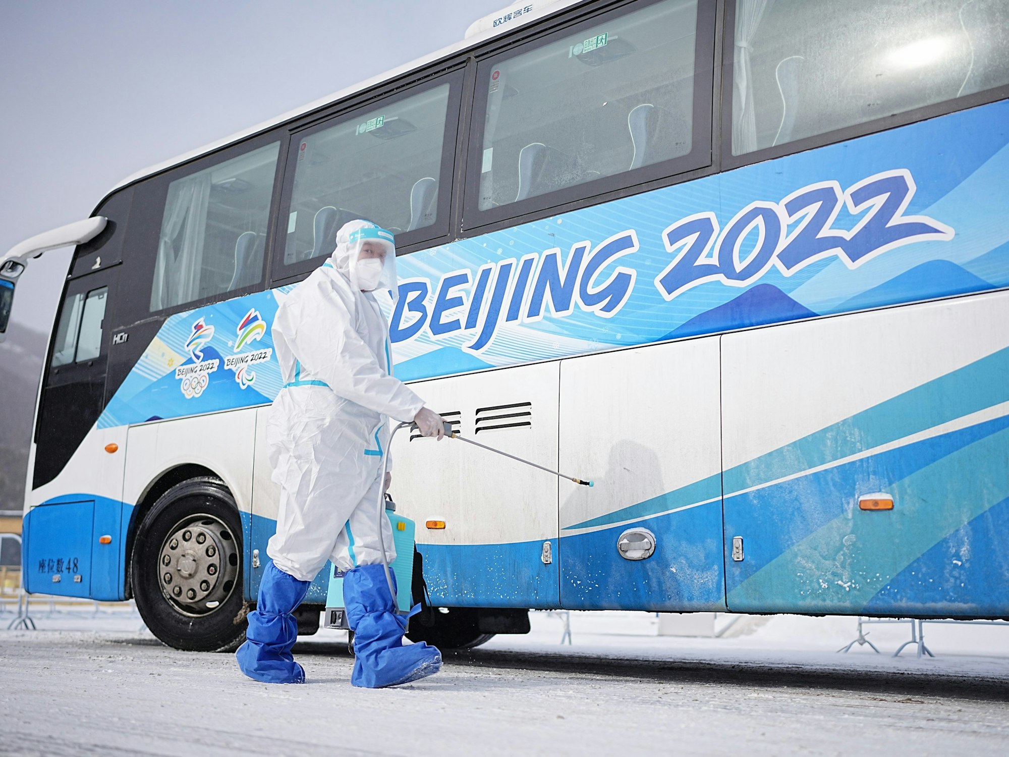 Zhangjiakou bei Peking: Ein Arbeiter besprüht einen Olympia-Bus.