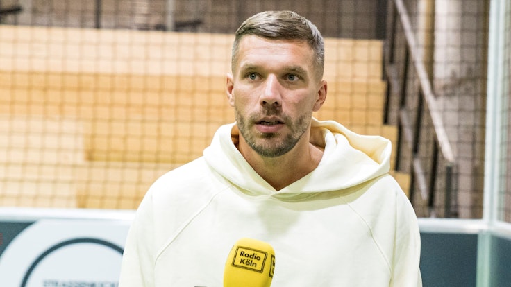 Lukas Podolski gibt ein Interview in Köln