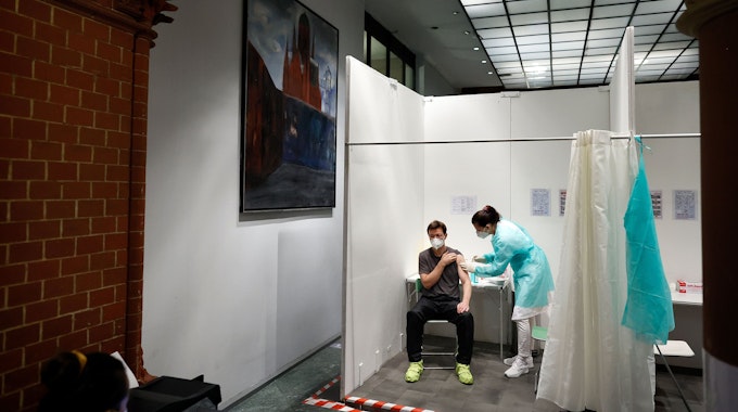 Eine Ärztin impft den Patienten Andre Wermter mit der Boosterimpfung mit dem Impfstoff Biontech in der Heilig-Kreuz-Kirche in Kreuzberg.
