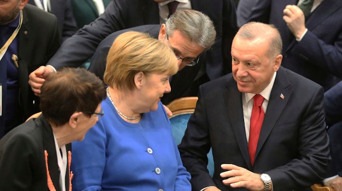 Die damalige Bundeskanzlerin Angela Merkel (CDU, M) unterhält sich Anfang 2020 mit dem türkischen Präsidenten Recep Tayyip Erdogan (r) zu Beginn einer Eröffnungszeremonie der Türkisch-Deutschen Universität: Erdogan vermisst eine Führungsfigur wie Merkel im Ukraine-Konflikt.