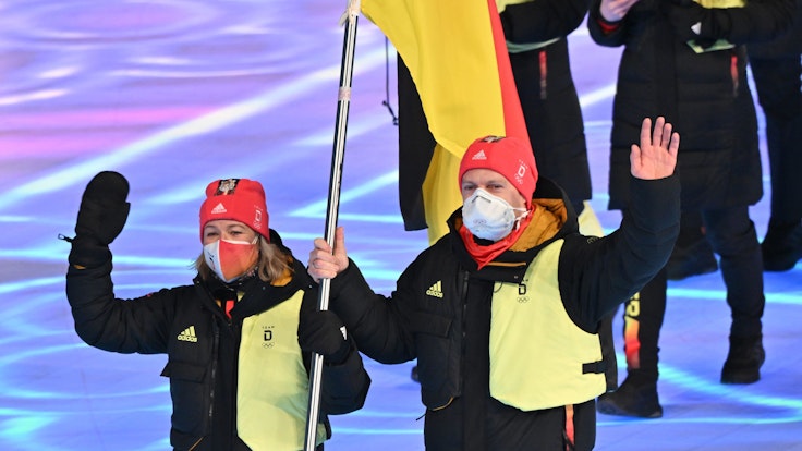 Claudia Pechstein und Francesco Friedrich tragen die deutsche Fahne ins Stadion
