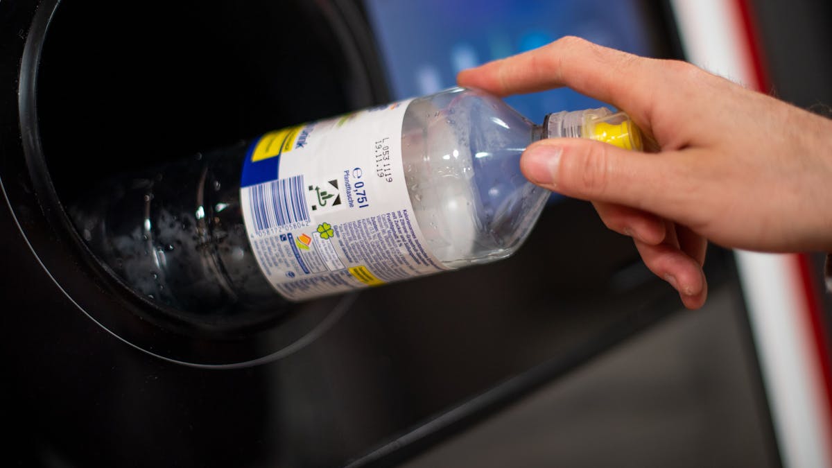 Ein Mann steckt eine Pfandflasche in einen Pfandflaschenautomaten in einem Supermarkt (Foto vom 8. April 2019)