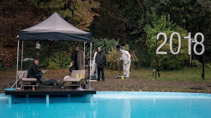Eine Szene eines Filmsets an einem Swimmingpool.