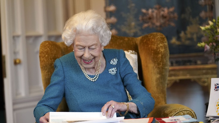 Königin Elizabeth II. blättert durch Dokumente.