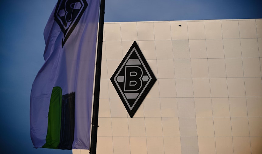 Die Borussia-Raute auf dem Gebäude „8 Grad“ im Gladbacher Borussia-Park. Dieses Foto stammt vom 24. November 2020. Im Vordergrund ist eine Borussia-Fahne zu sehen.