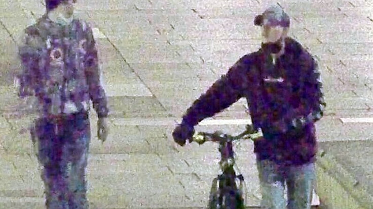 Zwei Männer, einer mit Fahrrad, gehen nebeneinander.