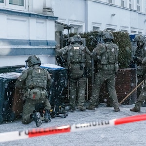 Beamte eines Spezialeinsatzkommandos (SEK) der Polizei stürmen eine Wohnung.