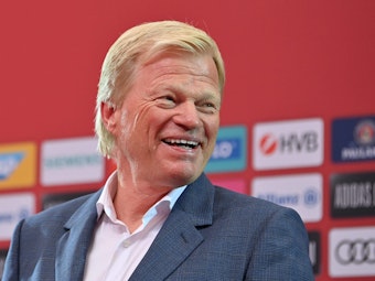 Oliver Kahn, Vorstandsvorsitzender der FC Bayern München AG, lacht auf dem Podium.