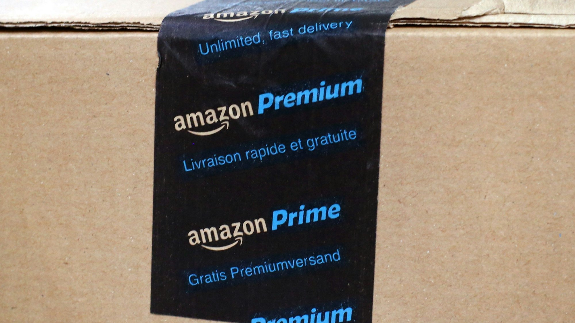 Ein fertig verpacktes Paket mit einem Aufkleber Amazon Prime liegt in einem Verteilzentrum.