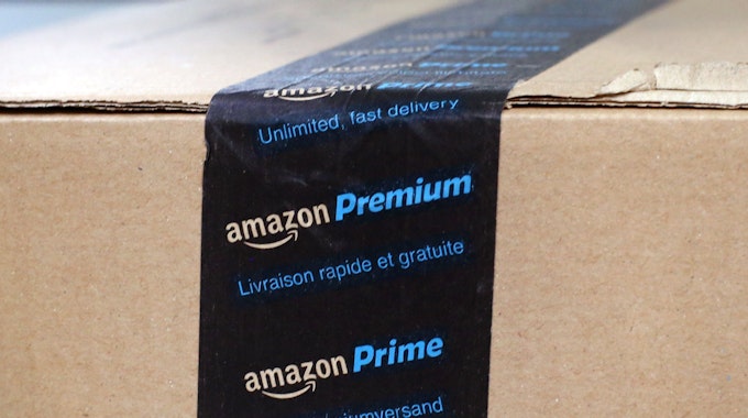 Ein fertig verpacktes Paket mit einem Aufkleber Amazon Prime liegt in einem Verteilzentrum.