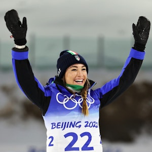 Dorothea Wierer reißt nach dem Gewinn einer Medaille ihre Hände hoch.