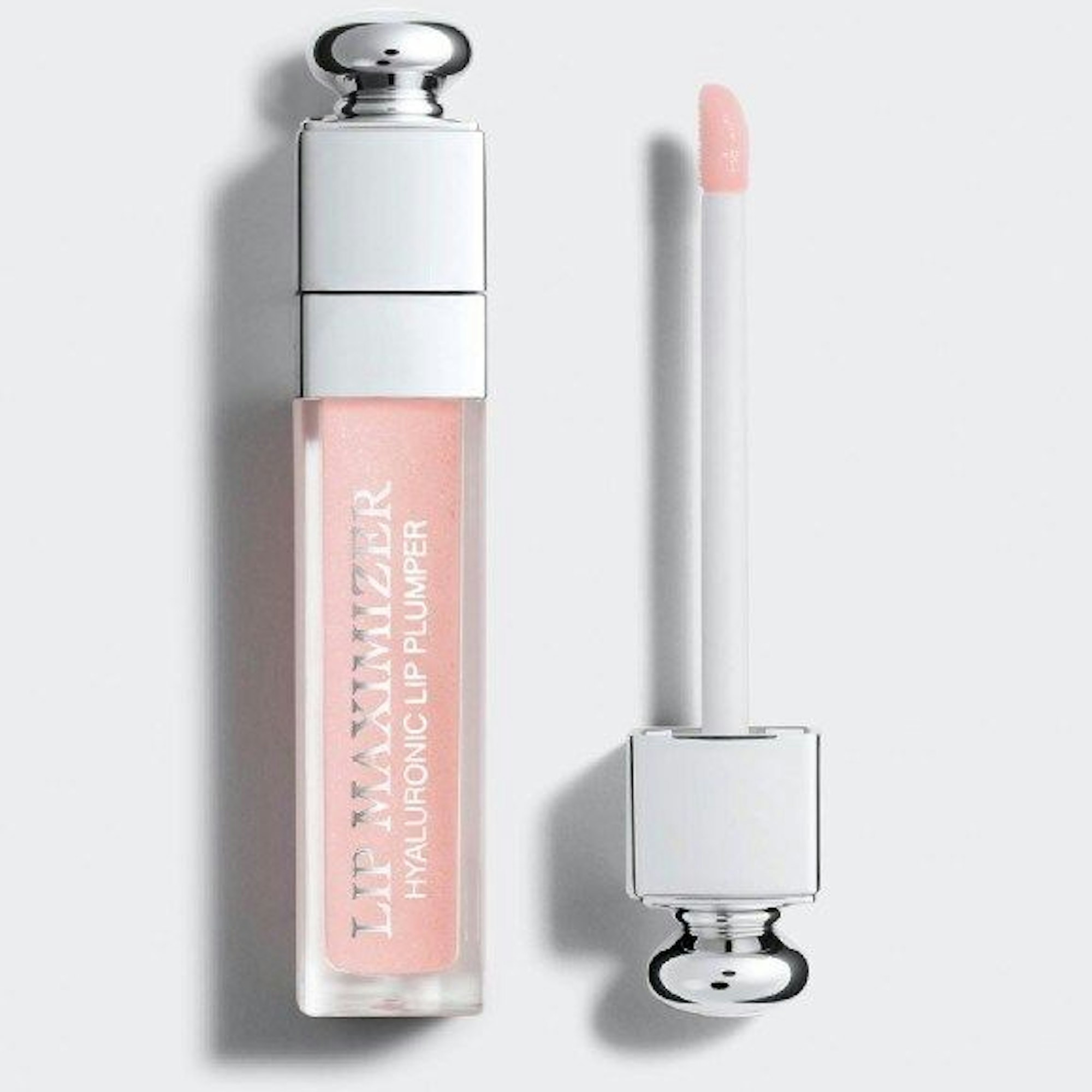 Ein Dior Addict Lip Maximizer liegt geöffnet auf einem weißen Hintergrund.