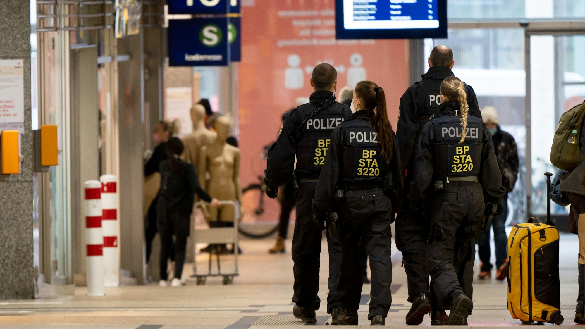 Polizisten gehen in einer Gruppe durch den Kölner Hauptbahnhof.