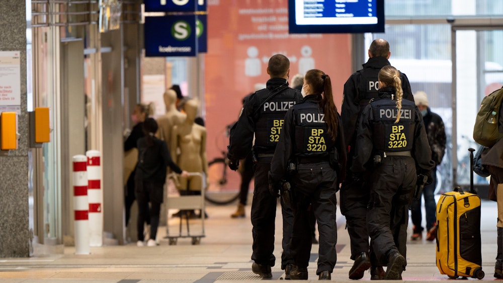 Polizisten gehen in einer Gruppe durch den Kölner Hauptbahnhof.