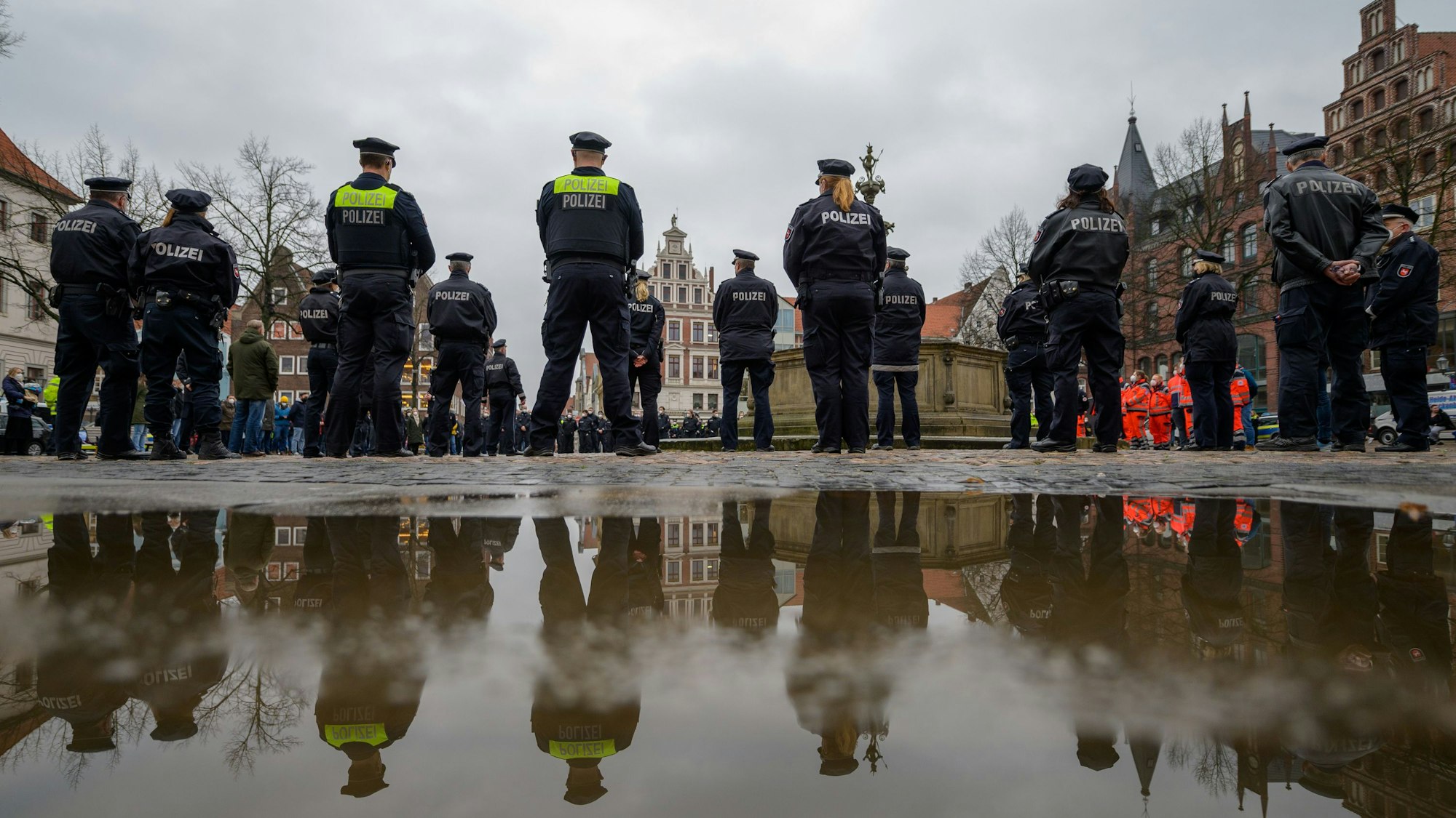 Polizisten stehen auf dem Marktplatz zusammen, um eine Schweigeminute für die in Rheinland-Pfalz getöteten Polizisten abzuhalten.