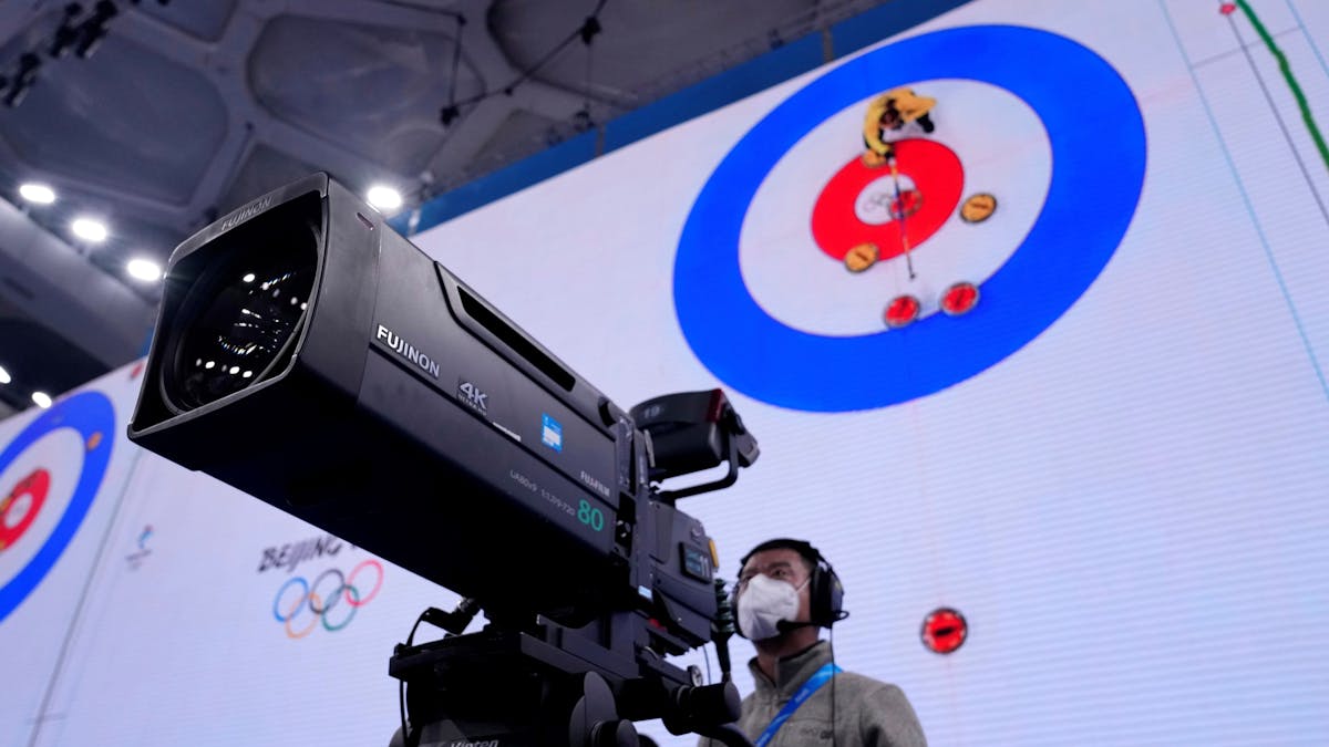 Ein Kameramann steht bei der Olympia-Übertragung der Curling-Halbfinals in Peking vor seinem Arbeitsgerät.