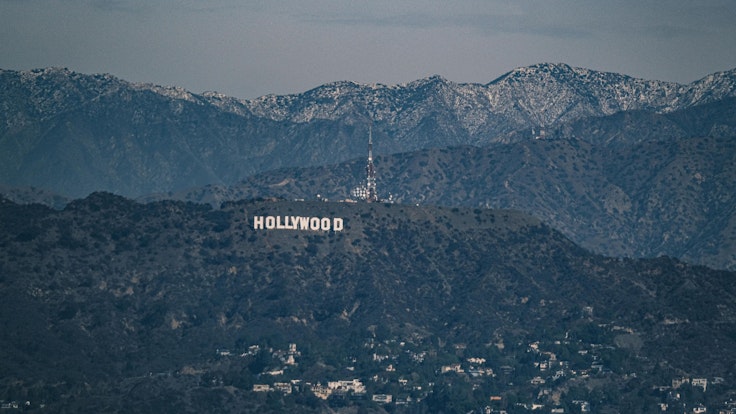 Der „Hollywood“-Schriftzug zeichnet sich vor Schneebedeckten Bergen ab.
