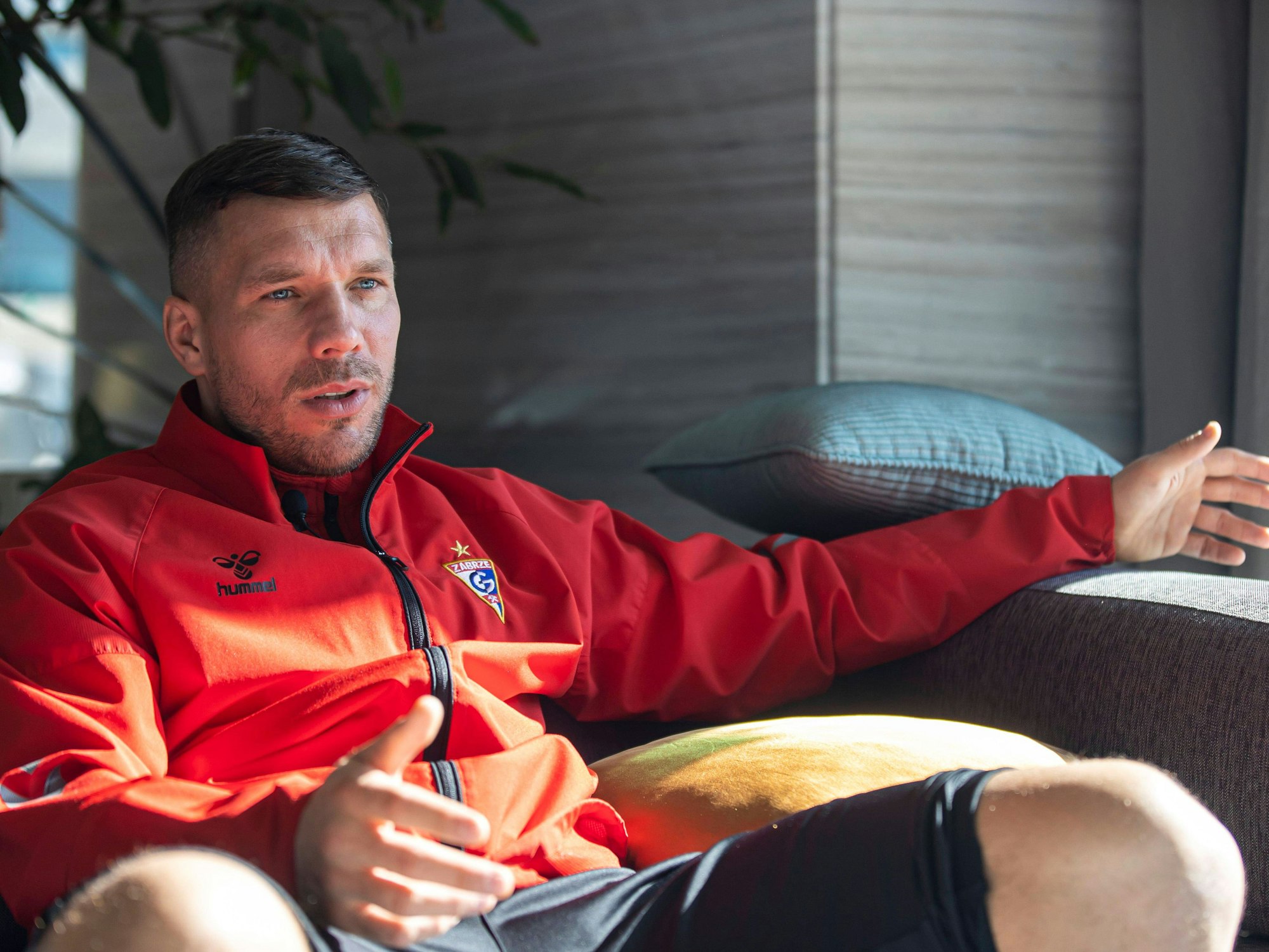 Lukas Podolski sitzt mit Trainingsjacke vonGórnik Zabrze am 21. Januar 2022 bei einem Interview.