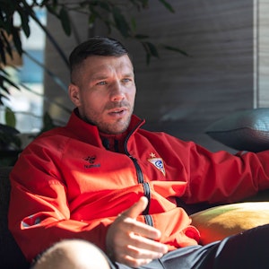 Lukas Podolski sitzt mit Trainingsjacke von Górnik Zabrze am 21. Januar 2022 bei einem Interview.
