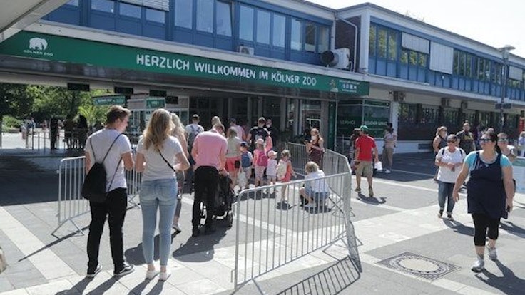 Menschen stehen in einer Warteschlange vor dem Kölner Zoo.