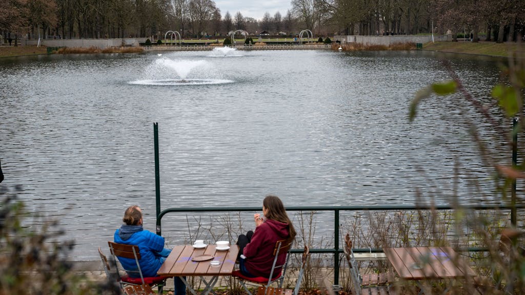Zwei Menschen in einem Café am Wasser im Blücherpark.