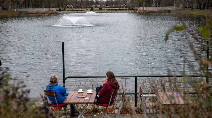 Zwei Menschen in einem Café am Wasser im Blücherpark.