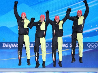 Constantin Schmid, Stephan Leyhe, Markus Eisenbichler und Karl Geiger hüpfen auf dem Podium bei Olympia.