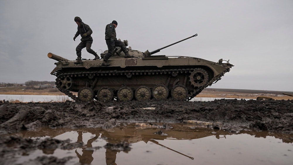 Zwei ukrainische Soldaten stehen während einer Schießübung am 10. Februar auf einem Panzer, der auf einem Feld steht.