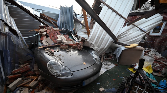 Reste eines eingestürzten Daches liegen am Samstag (19. Februar) nach dem Orkan „Zeynep“ in Eversmeer (Niedersachsen) auf einem Porsche. Ein dreister „Notruf“ sorgte in Ostfriesland für reichlich Wut.