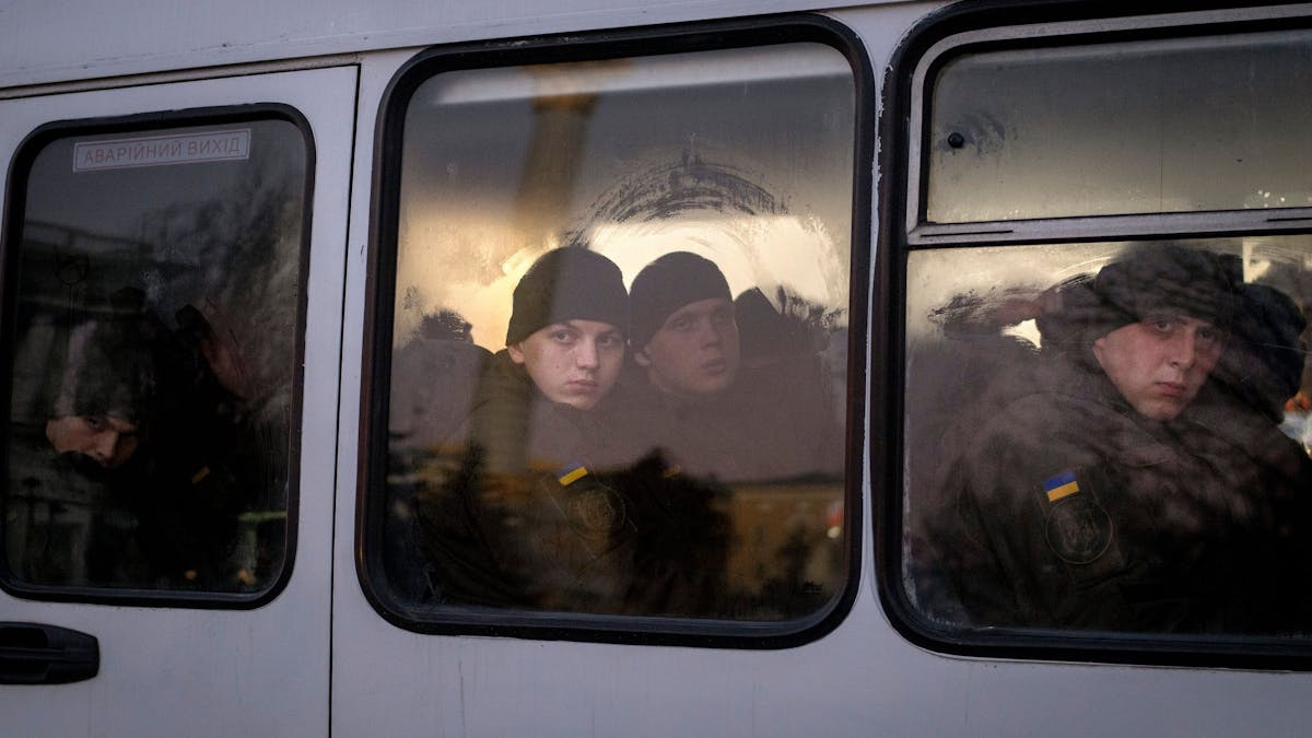Mitglieder der ukrainischen Nationalgarde schauen Mitte Februar aus dem Fenster, während sie in einem Bus durch Kiew fahren. Die Lufthansa streicht Flüge von und nach Kiew, das Auswärtige Amt ruft alle Deutschen dazu auf, das Land zu verlassen.