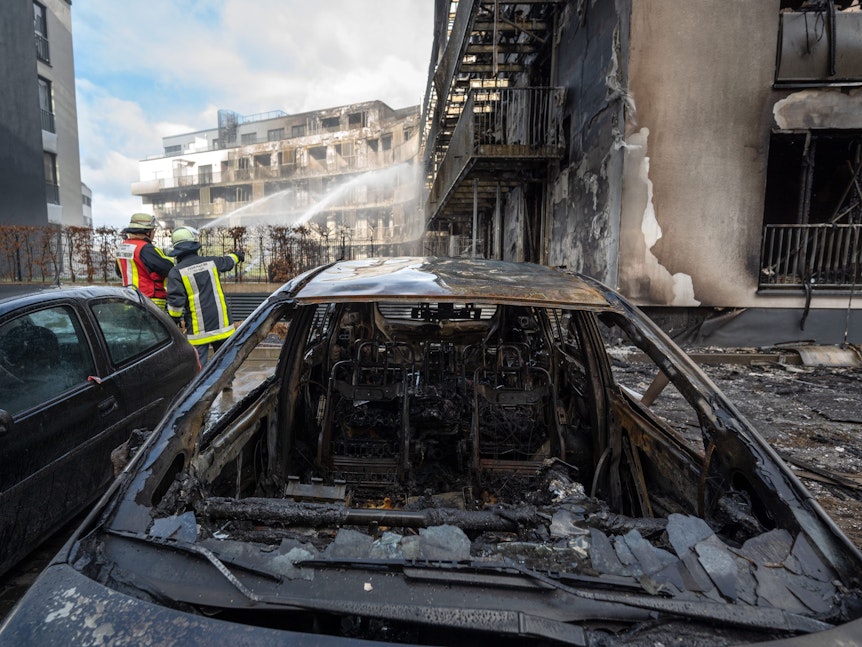 Ausgebrannte Autos nach Feuer in Wohnhaus.