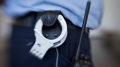 Blick auf die Handschellen eines Polizisten