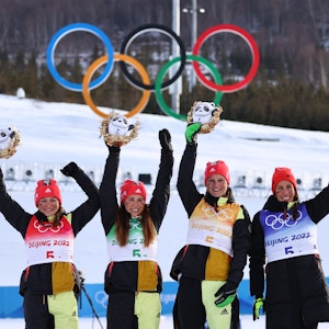 Deutschlands Zweitplatzierte Katherine Sauerbrey, Katharina Hennig, Victoria Carl und Sofie Krehl (l-r) auf dem Podium nach dem Staffel-Rennen der Langlauf-Damen am 12. Februar 2022.