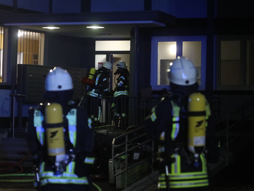 Feuerwehr-Kräfte betreten ein Wohnhaus in Köln.