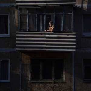 23.02.2022, Ukraine, Novoluhanske: Ein Mann blickt nach einem Artilleriebeschuss bei Sonnenuntergang von einem Balkon. Die Ukraine rüstet sich für einen Krieg mit Russland. Präsident Selenskyj kündigte eine Teilmobilmachung von Reservisten an. Foto: Evgeniy Maloletka/AP/dpa +++ dpa-Bildfunk +++
