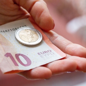Eine Person hält 12 Euro in der Hand. Das Bundeskabinett hat die geplante Erhöhung des Mindestlohns auf 12 Euro auf den Weg gebracht.