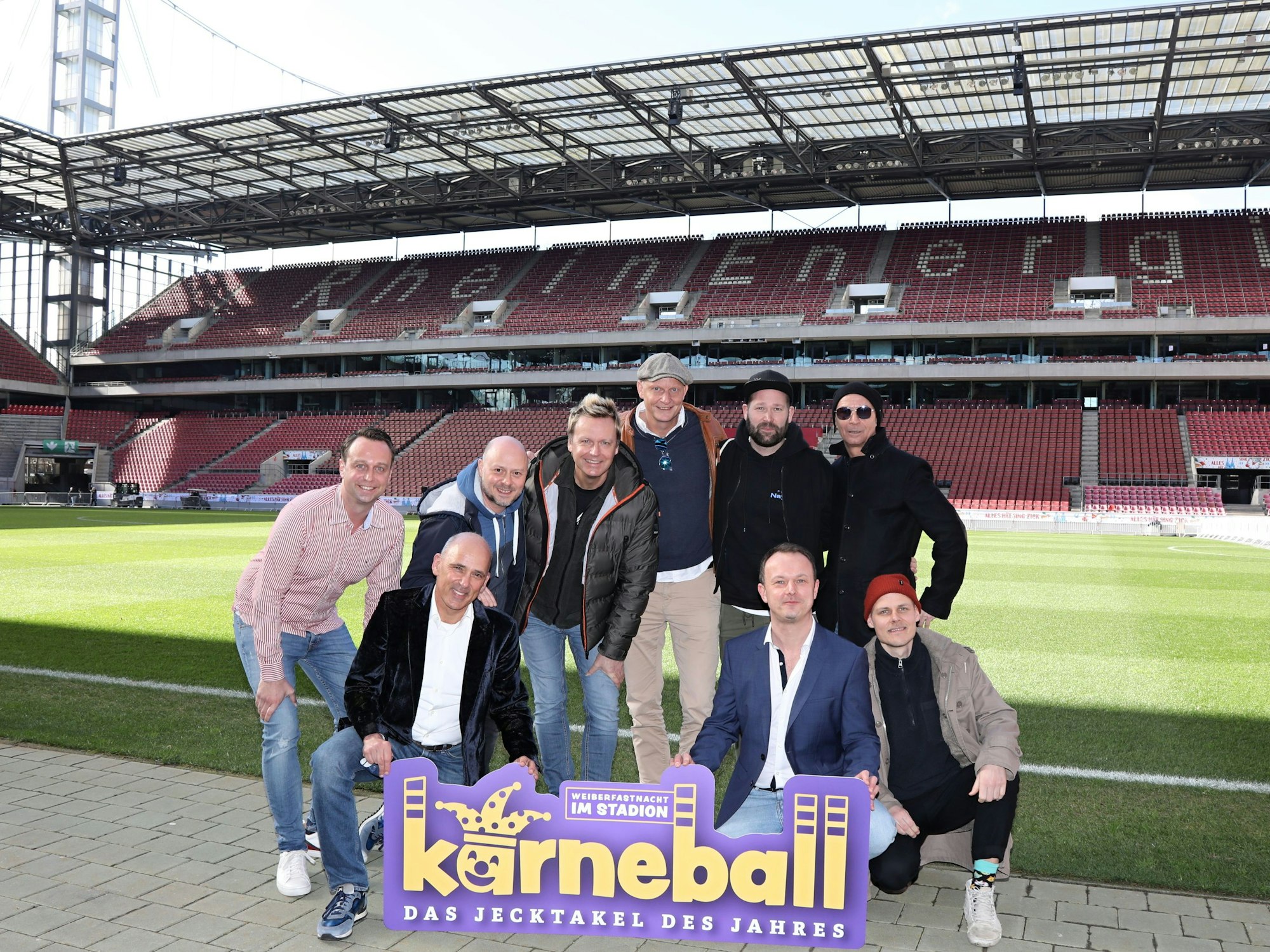 Künstler posieren im Stadion in Köln und schauen in die Kamera.