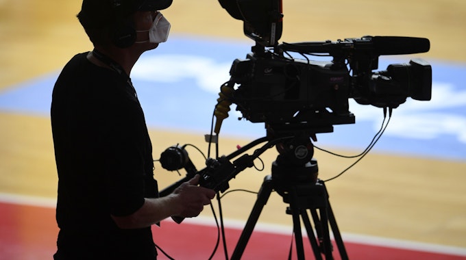 Ein Kameramann bei der Übertragung eines Basketball-Spiels.