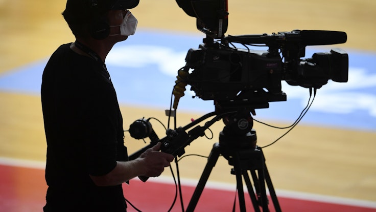 Ein Kameramann bei der Übertragung eines Basketball-Spiels.