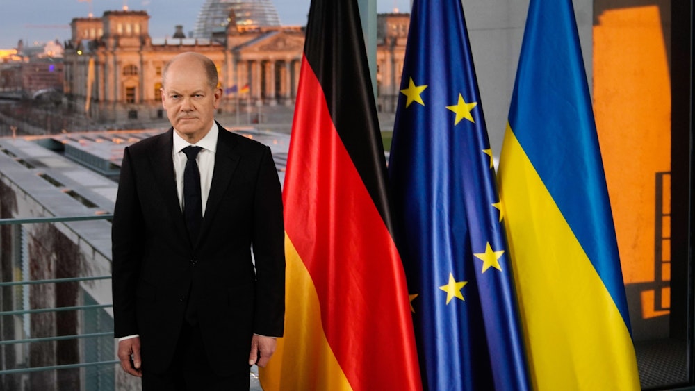Bundeskanzler Olaf Scholz steht bei einer Fernsehansprache zur Lage zwischen Russland und der Ukraine vor den Fahnen von Deutschland, der EU und der Ukraine.