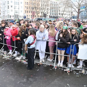 Menschen stehen am Absperrgitter an der Zülpicher Straße.
