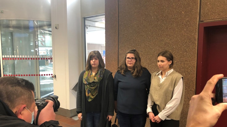 Drei Frauen treten vor die Presse.